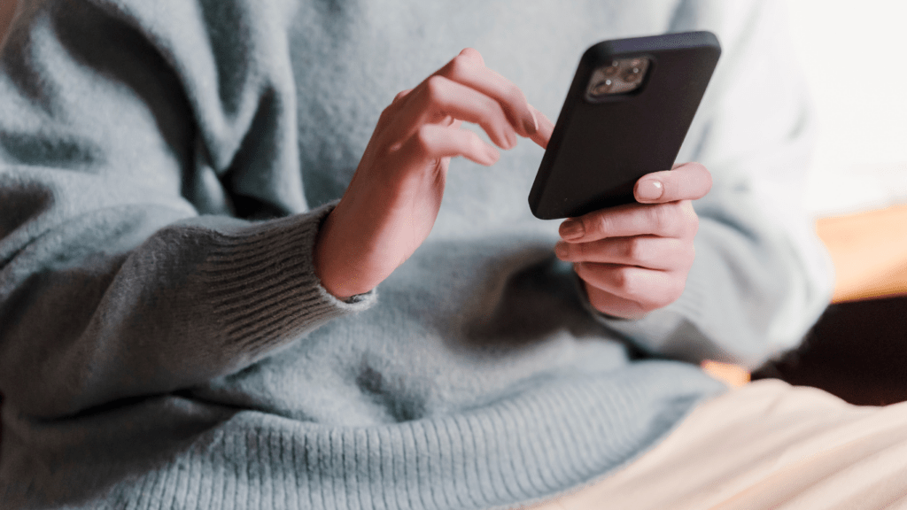 A person sitting on a couch holding a cell phone