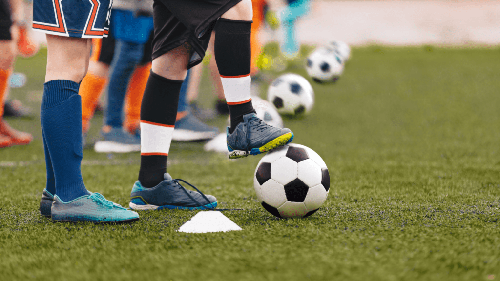 a group of children are standing around a soccer ball