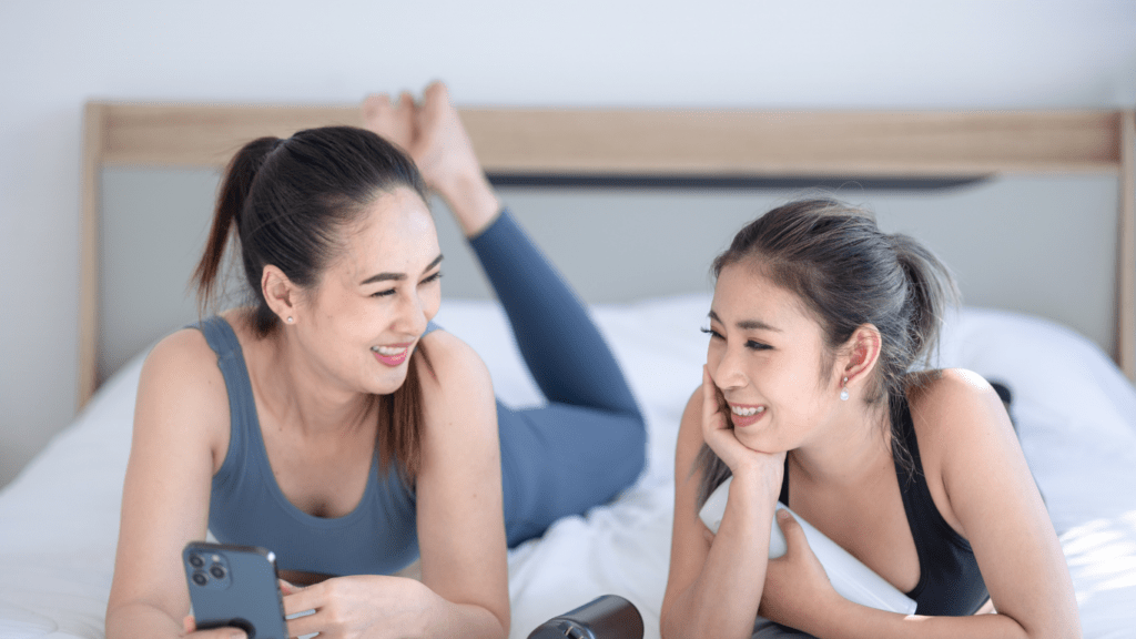 a person laying on a bed looking at a cell phone