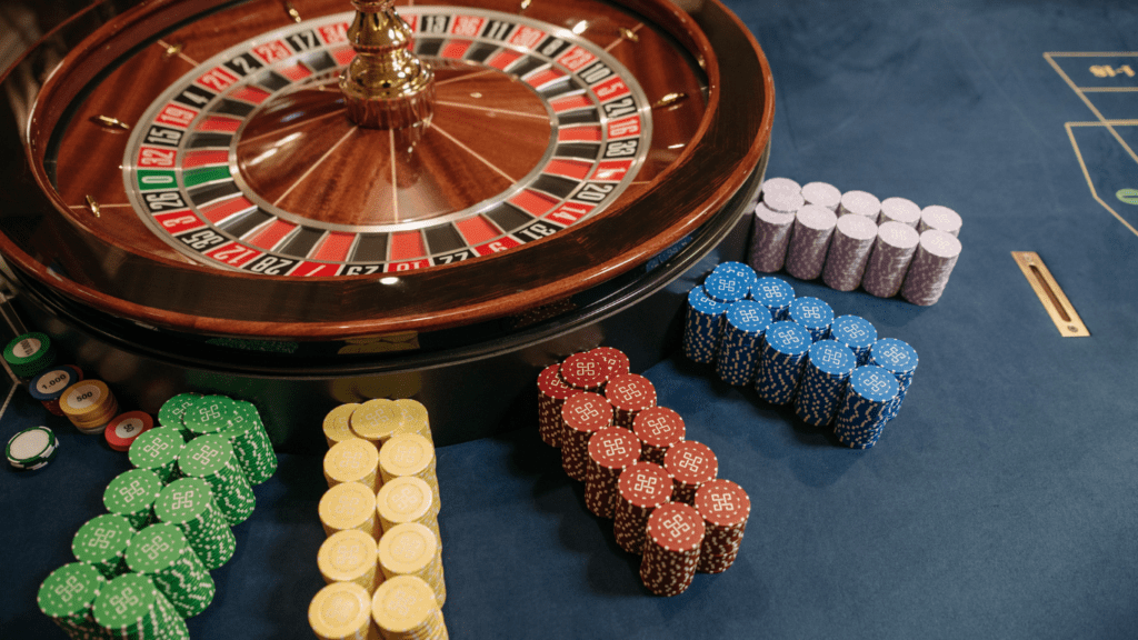 Stacked poker chips beside casino roulette