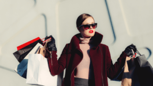 A person holding shopping bags in front of a building