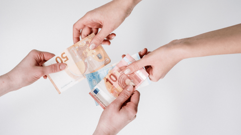 Two people sitting on a couch holding money