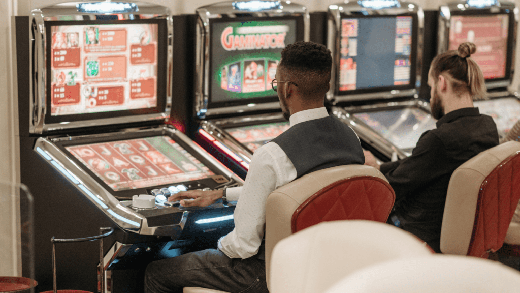 a group of people playing slot machines at a casino