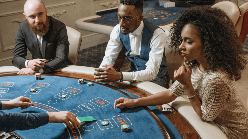 a group of people sitting around a table playing cards