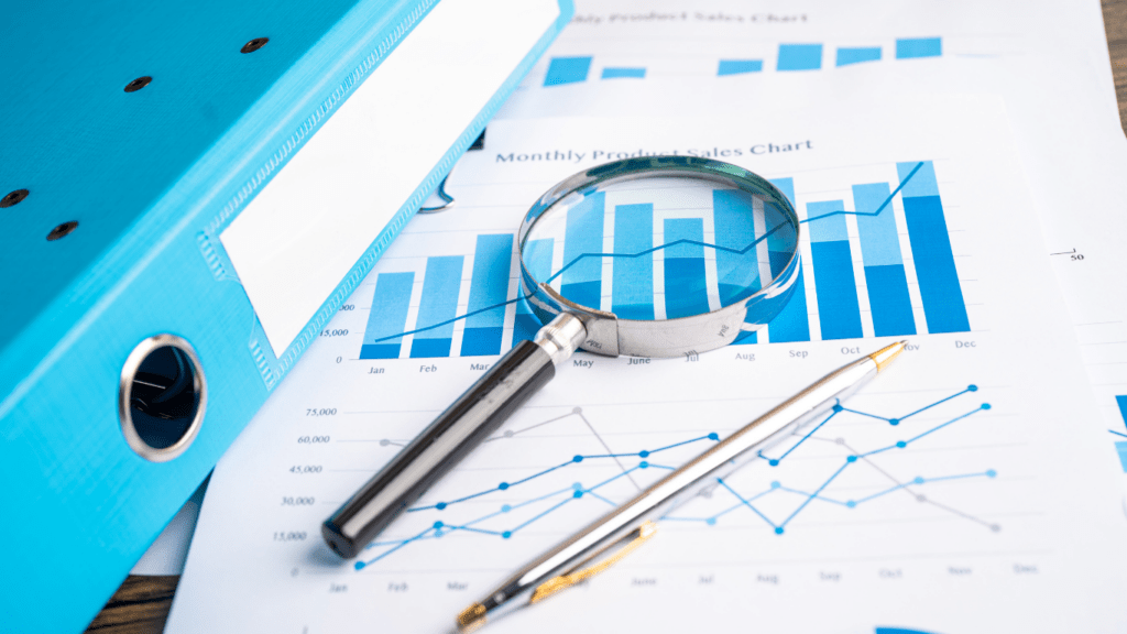 a magnifying glass and a pen on top of a business report