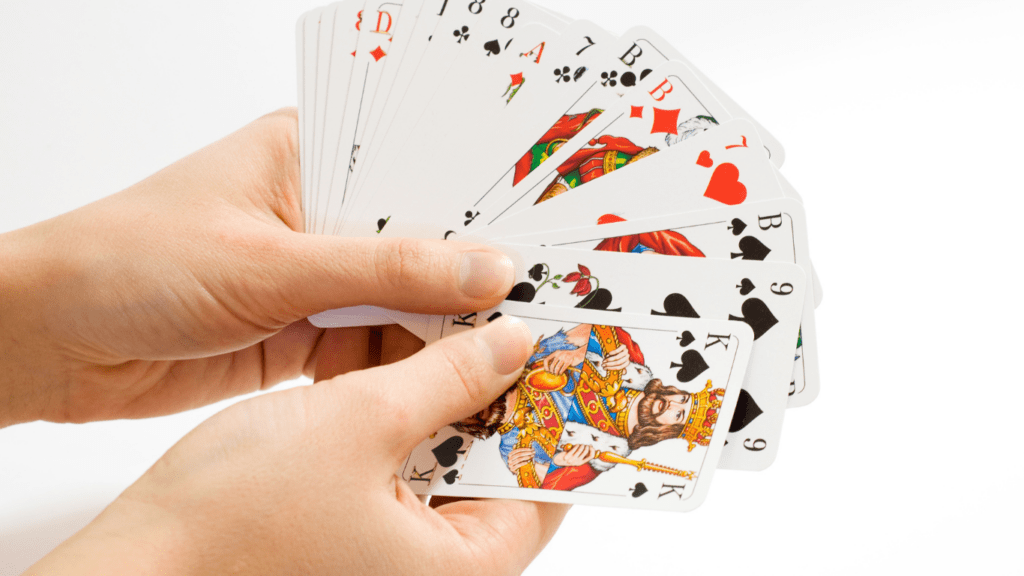 a person holding up a deck of playing cards