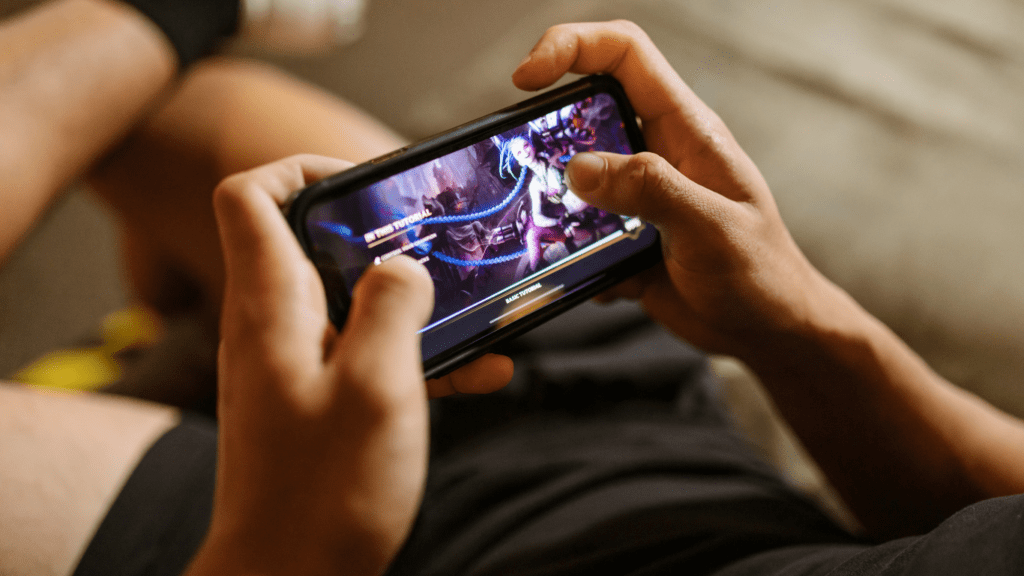 a person holding up a smartphone with a video game on it