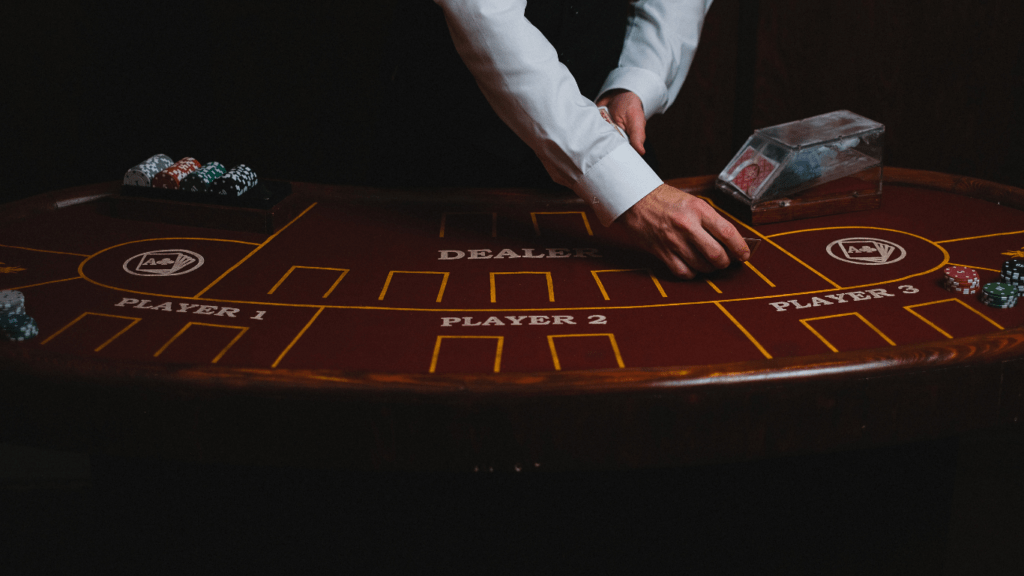 a person in a suit and tie playing cards at a casino table