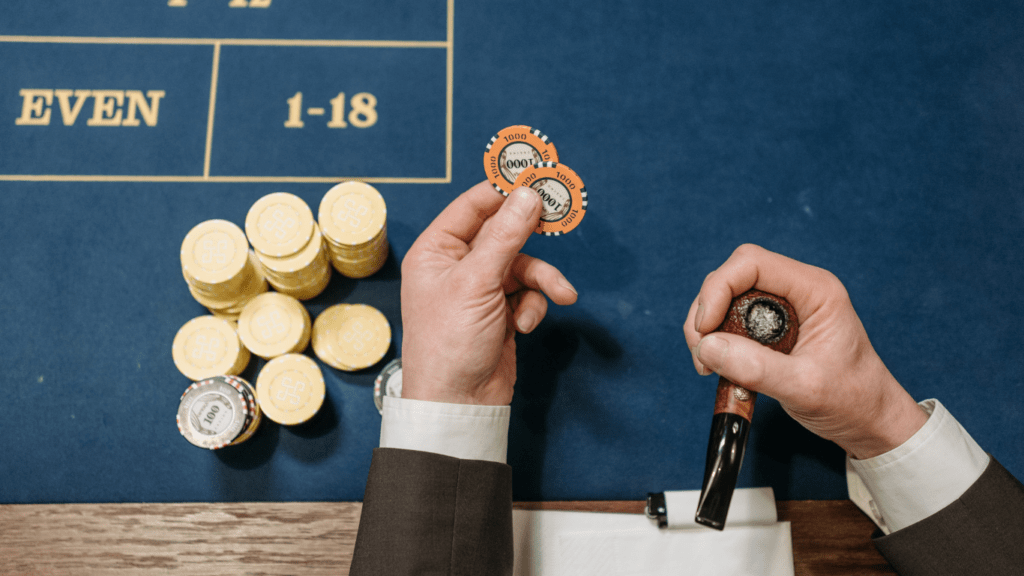 a person is holding a stack of chips on a casino table