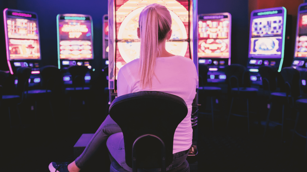 a person sitting in front of a slot machine