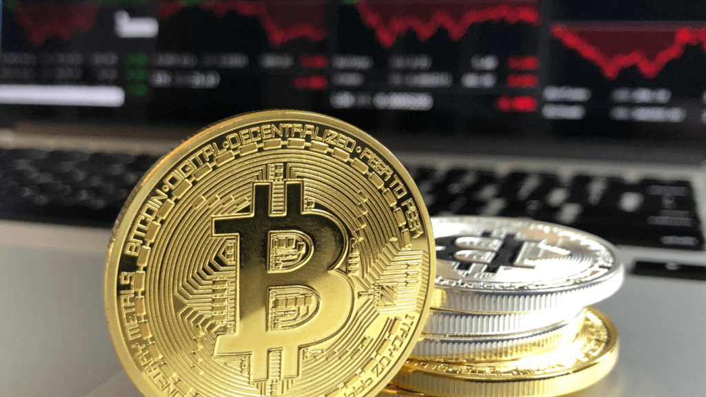 gold and silver coins on a table with a stock chart