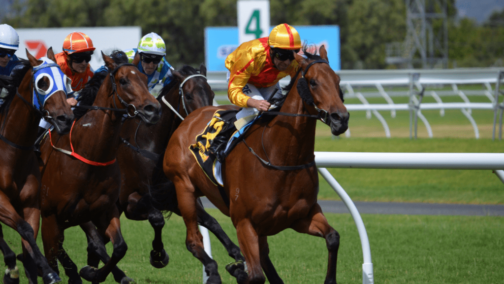 three jockeys are racing horses down the track